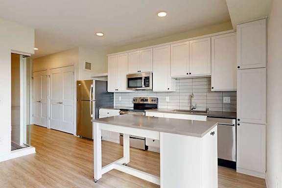 A kitchen with white cabinets and a stainless steel appliances.