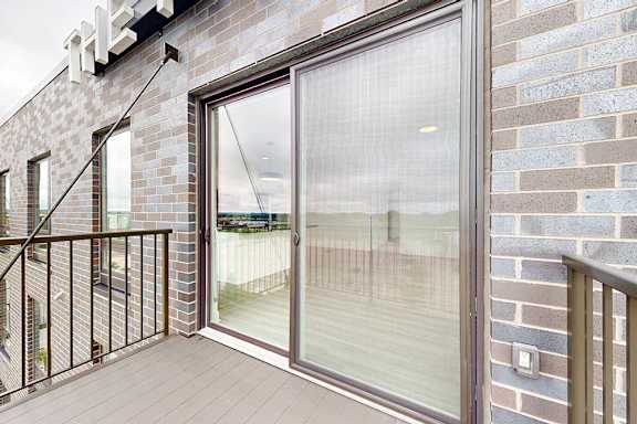 A balcony with a glass door and a metal railing.