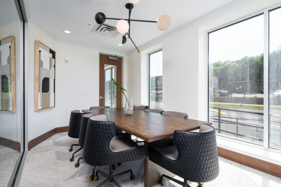 Work from home conference style room with large rectangle table and rolling chairs surrounding the table.