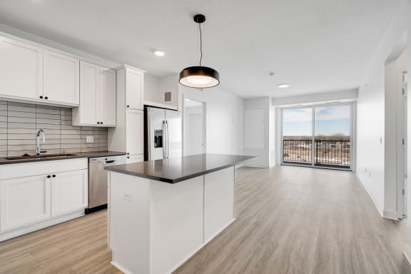 Large kitchen with countertop island white cabinets and matching stainless steel appliances at The Rowan Apartments in Eagan Minnesota