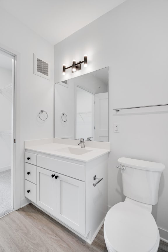 Bathroom with white vanity for storage and large mirror with great lighting at The Rowan Apartments in Eagan Minnesota