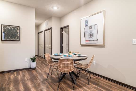 A dining room with a table set for four.