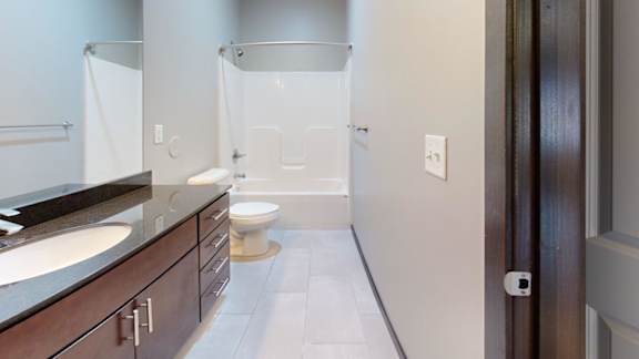 A bathroom with a toilet, sink, and shower.