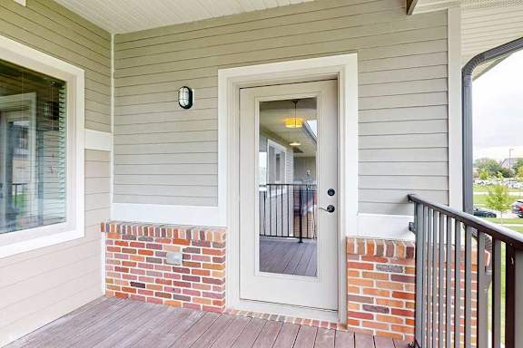 A balcony with a windowed door leading into the living room.