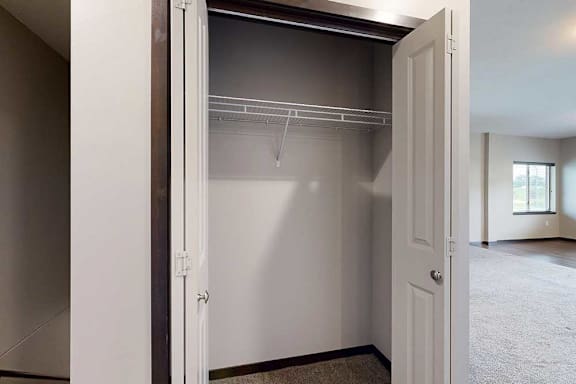 A double-door closet with a built-in wire shelf, at the top of the stairway.