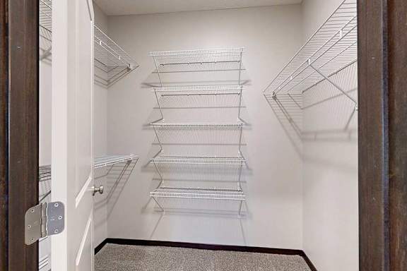 An oversized walk-in closet with several built-in wire shelves.
