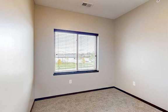 A carpeted den space with a window.