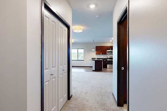 A short hallway with a coat closet, and a doorway to the attached bathroom.