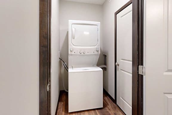 A stacked washer and dryer in a laundry room.