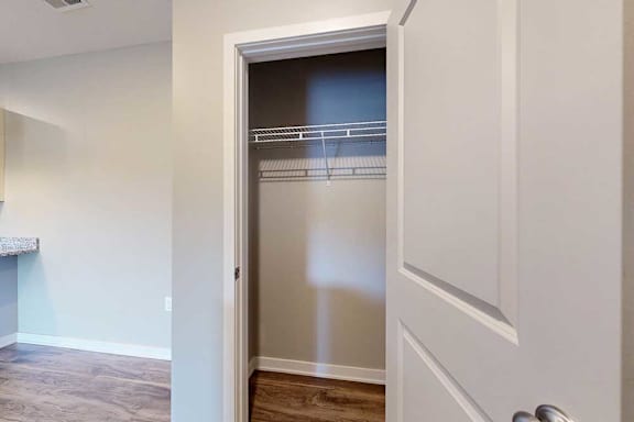 A coat closet with a built-in wire shelf, at the top of the stairway.