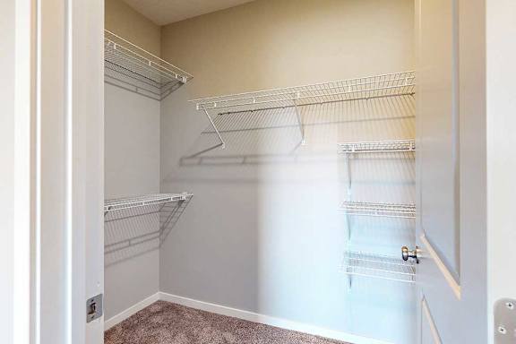 An oversized walk-in closet with several built-in wire shelves.