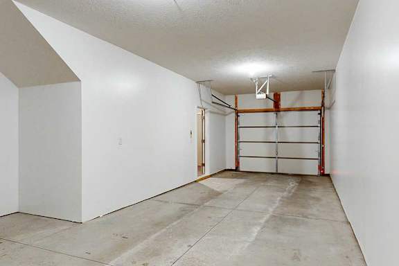 A two-car tandem garage with an extra built-in storage space under the stairs.