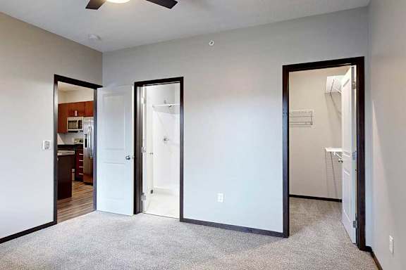 A carpeted bedroom with an attached bathroom and walk-in closet.