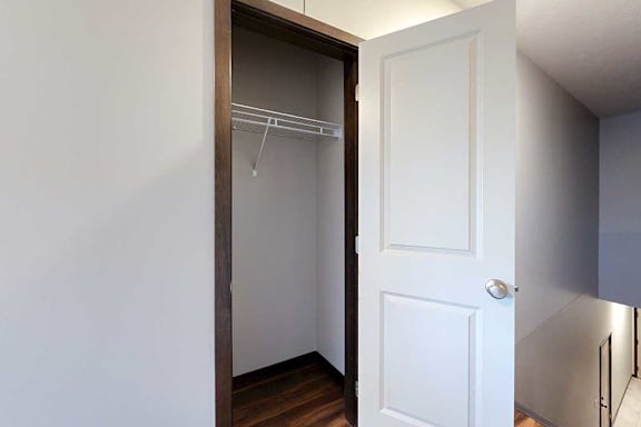 A coat closet with a built-in wire shelf.