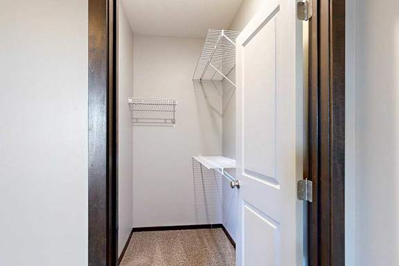 An oversized walk-in closet with several built-in wire shelves.