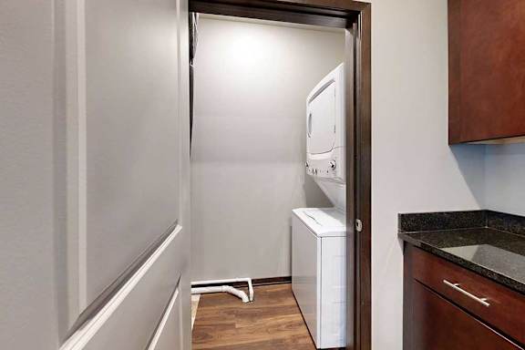 A stacked washer and dryer in a room off the kitchen.