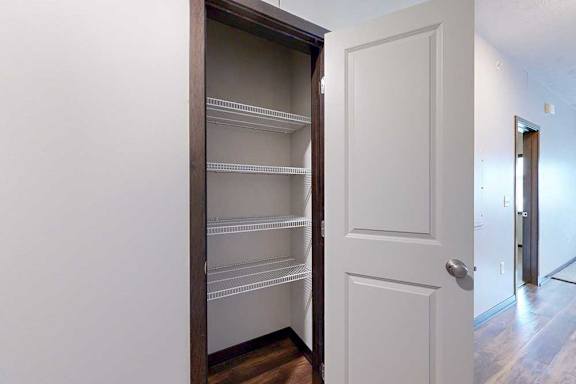 A storage closet with built-in wire shelves.