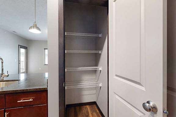 A kitchen pantry with several built-in wire shelves.