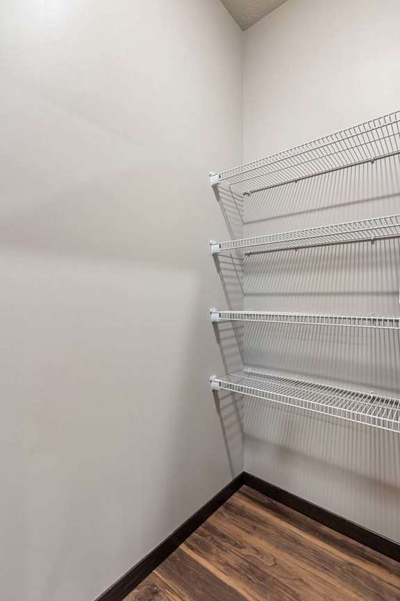 Walk-in pantry or storage closet with white wire shelving and generous vertical storage space.