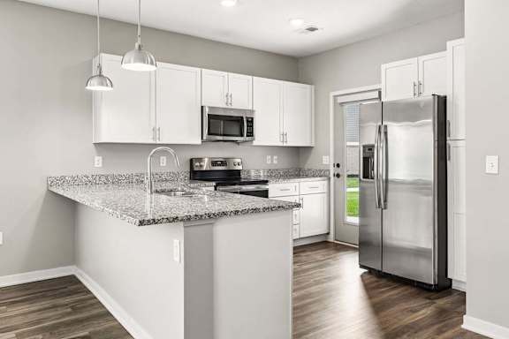 A kitchen with a granite countertop and stainless steel appliances.