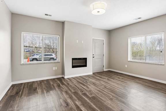 A room with a fireplace and a window with blinds.