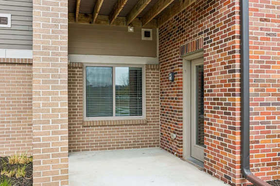 A red brick house with a window and a door.
