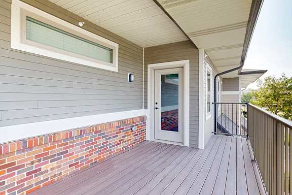 A spacious balcony with a windowed door into the living room.