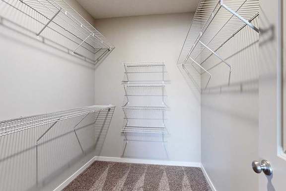 An oversized walk-in closet with several built-in wire shelves.
