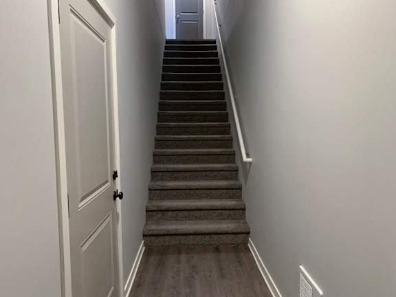 A staircase with a white door on the left side.