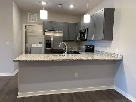 A kitchen with a granite countertop and stainless steel appliances.