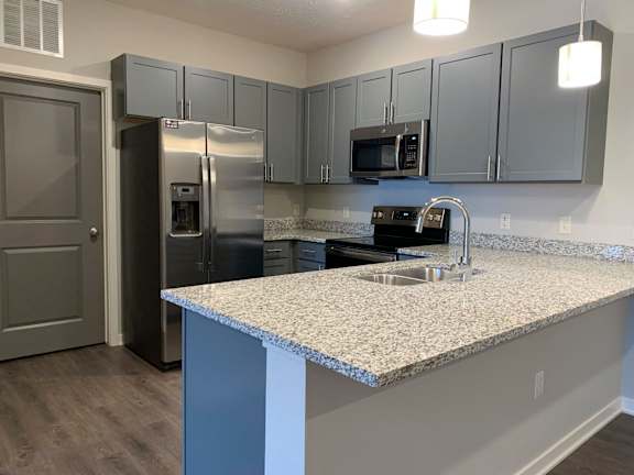 A kitchen with a granite countertop and stainless steel appliances.