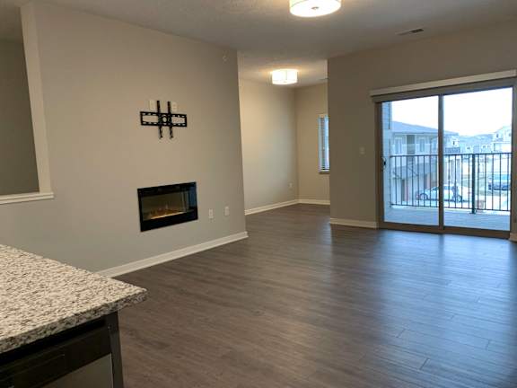 A room with a fireplace and sliding glass doors.