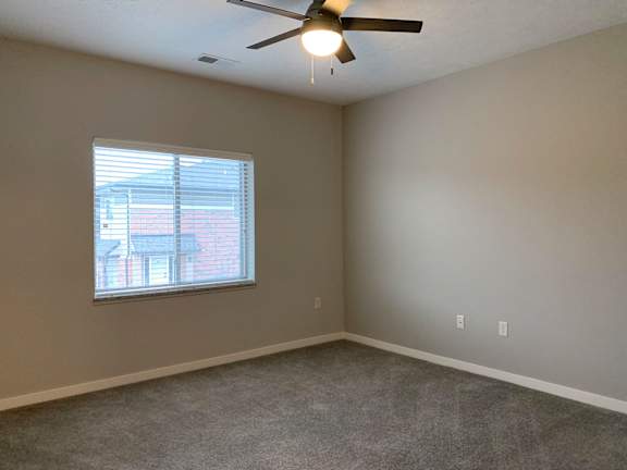 A room with a ceiling fan and a window.
