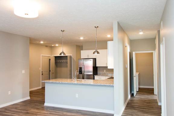 A kitchen with a granite countertop and stainless steel appliances.