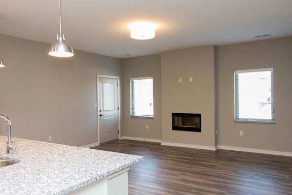 A kitchen with a sink and a fireplace in the living room.