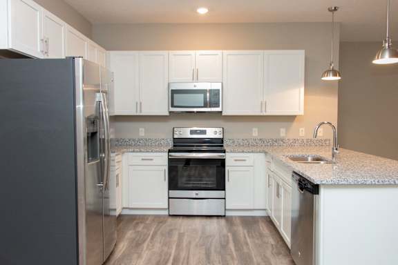 A kitchen with white cabinets and a granite countertop.