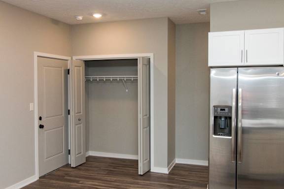 A kitchen with a refrigerator, a door and a cupboard.