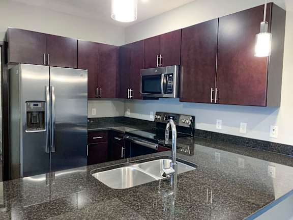 A kitchen with a granite counter top and stainless steel appliances.