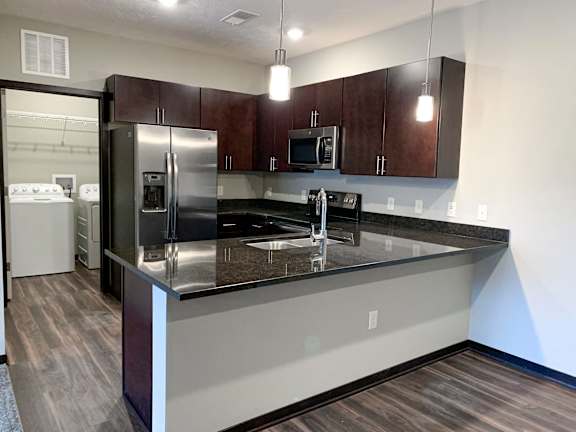 A kitchen with dark wood cabinets and stainless steel appliances.