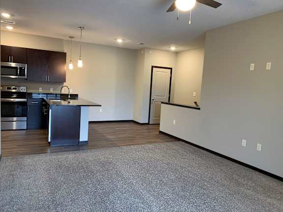 A spacious kitchen with dark wood cabinets and stainless steel appliances.