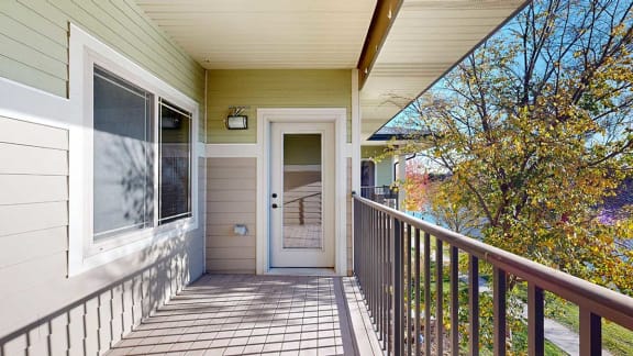 a balcony overlooking a pond with a window to the bedroom and a door to the living room