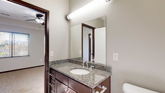 a bathroom with a granite countertop sink and a mirror