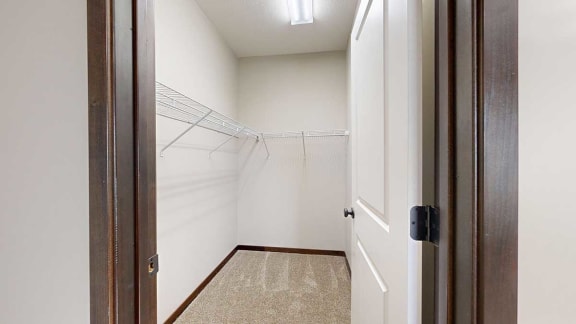 a long walk-in closet with built-in shelving and hanging space