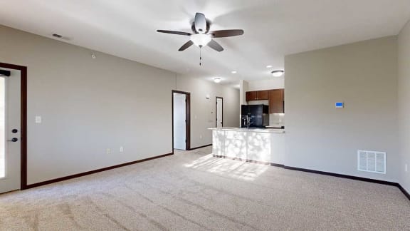 an open-concept living room and kitchen with a ceiling fan