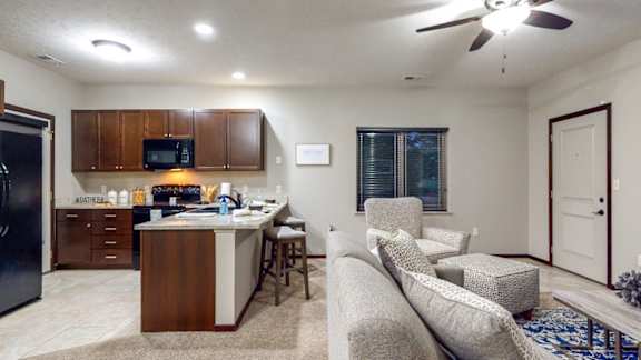 A kitchen with a refrigerator, microwave, and cabinets.