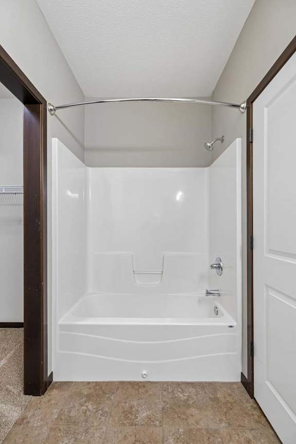 A white bathroom with a tub and a shower.
