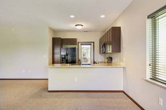 A kitchen with a white countertop and brown cabinets.