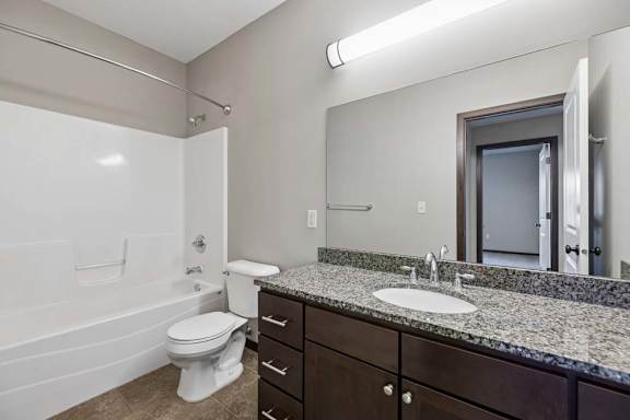 A bathroom with a white toilet, sink, and bathtub.
