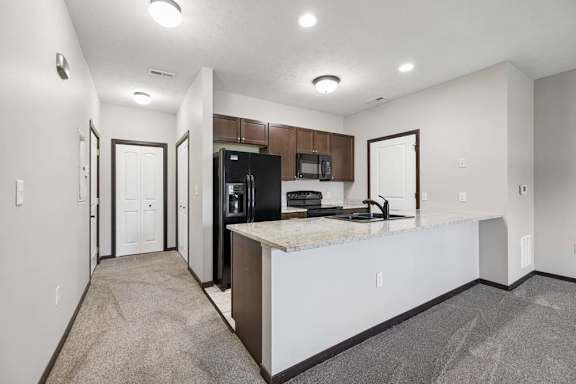 A kitchen with a refrigerator, microwave, and oven.