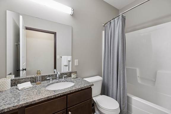 Apartment bathroom shower with sliding glass door, white surround, chrome trim, and neutral walls.